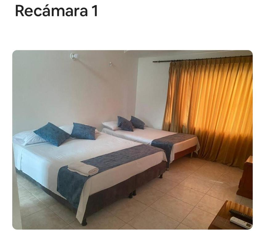 two beds in a room with a window at apartamento dúplex con piscina en el Rodadero in Rodadero