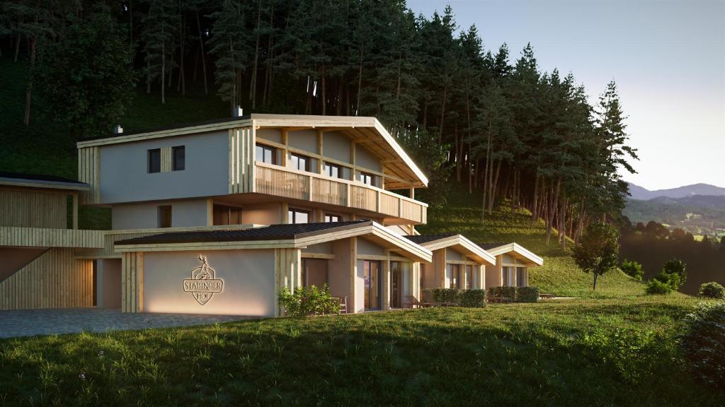 une grande maison au sommet d'une colline avec des arbres dans l'établissement Stabingerhof Chalets & Apartment-Farm stay, à Bressanone