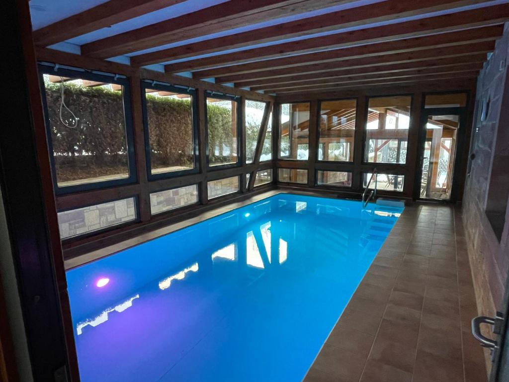 una piscina en una casa con ventanas en Entspannung im Wald - mit Schwimmbad, en Heßles