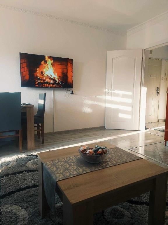 ein Wohnzimmer mit einem Tisch und einem Gemälde an der Wand in der Unterkunft Apartman Time in Brčko