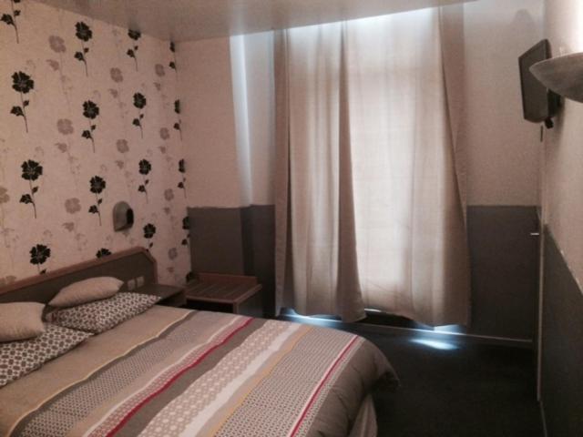 a small bedroom with a bed and a window at Le Terminus in Villeneuve-sur-Lot