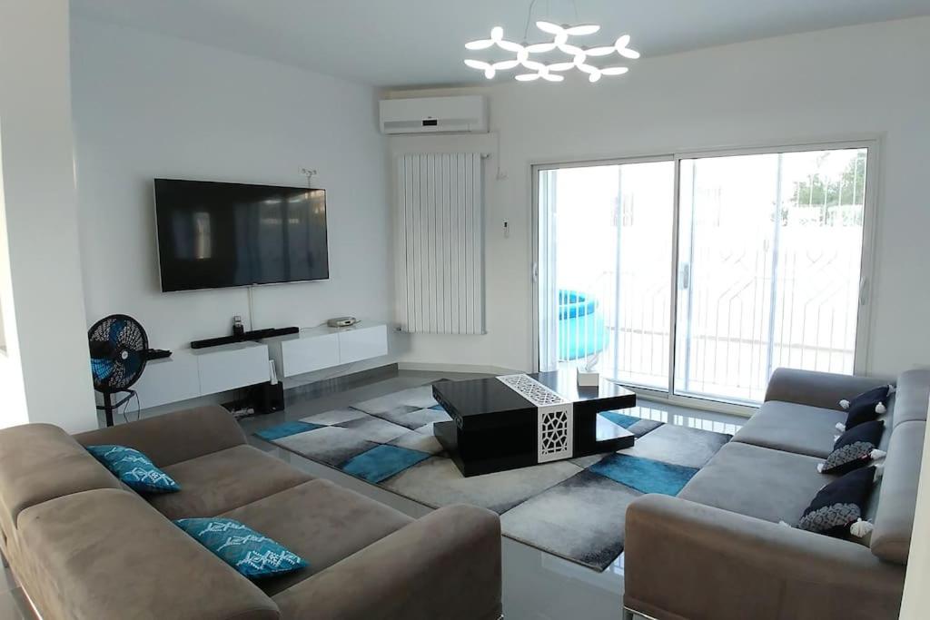 a living room with two couches and a flat screen tv at Villa Romana Monastir in Monastir