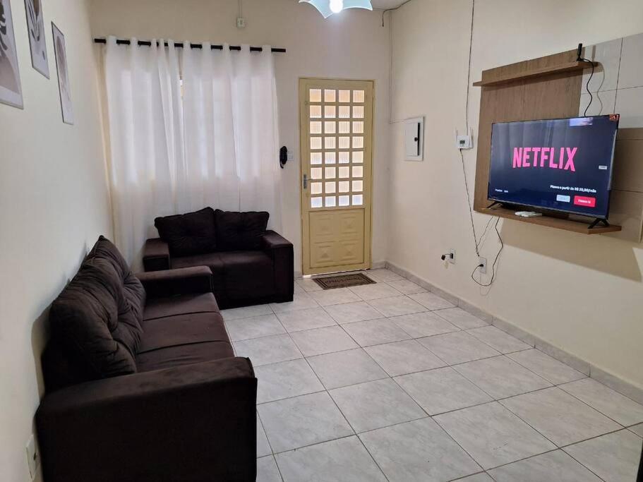 a living room with two couches and a television at Apartamento Ipês- Excelente localização in Corumbá