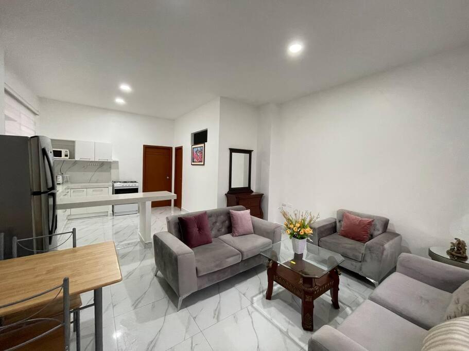 マチャラにあるConfortable Apartamento # 2 planta bajaのリビングルーム(ソファ2台付)、キッチンが備わります。