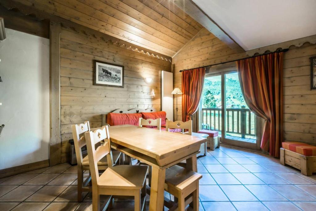 une salle à manger avec une table et des chaises en bois dans l'établissement Les Chalets Du Gypse - LES CHALETS DU GYPSE A04 MAE-3861, à Saint-Martin-de-Belleville