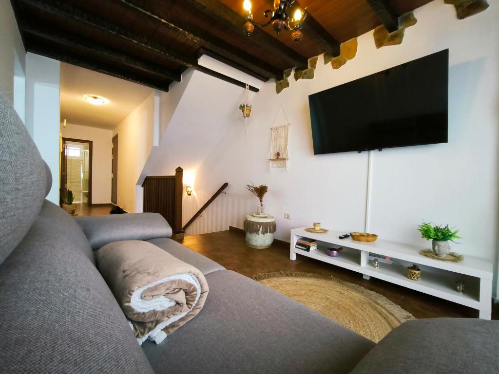 Una sala de estar con un sofá y un televisor de pantalla plana. en Casa Zamora, en Los Realejos
