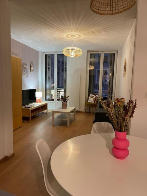 - un salon avec une table blanche et un vase dans l'établissement Mulhouse hyper centre - Grand T3- Aux bons enfants, à Mulhouse