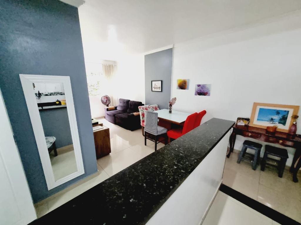eine Küche und ein Wohnzimmer mit einem Tisch und einer Couch in der Unterkunft Edifício Plaza de Saint Martin in Santos