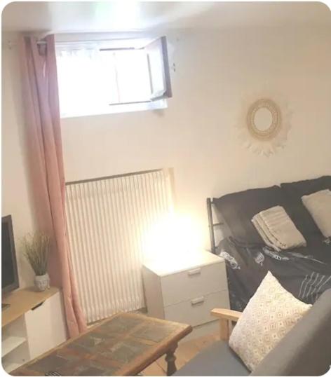 - un salon avec un lit, une table et une fenêtre dans l'établissement Studio Sarcelles Village, à Sarcelles