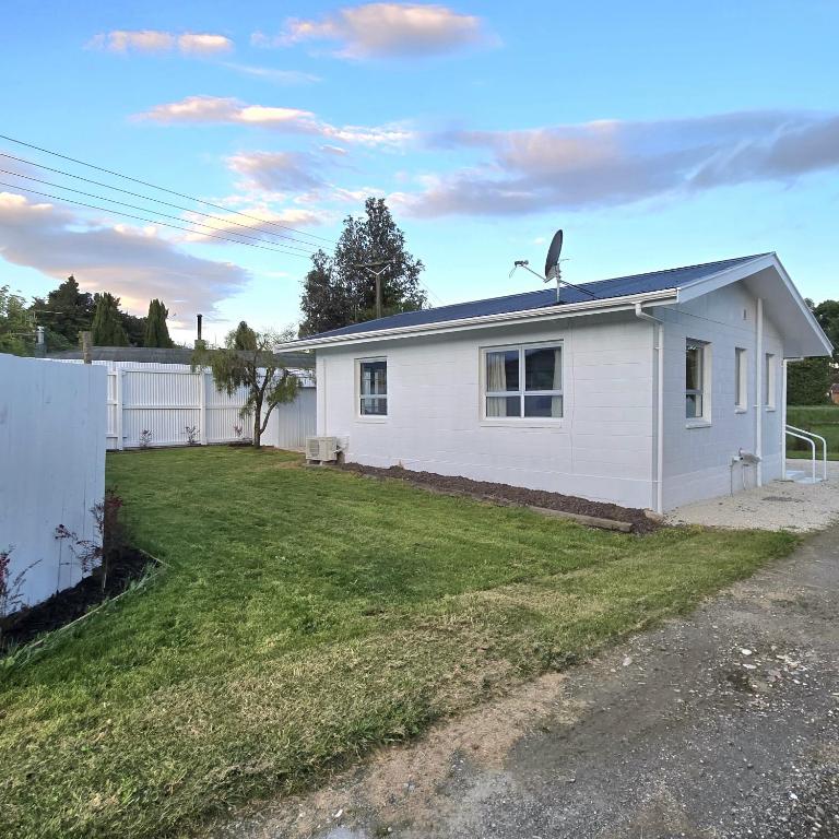 una casa bianca con cortile di Pasture Views Cottage a Riwaka