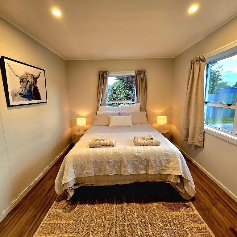 una camera da letto con un letto con due asciugamani sopra di Pasture Views Cottage a Riwaka
