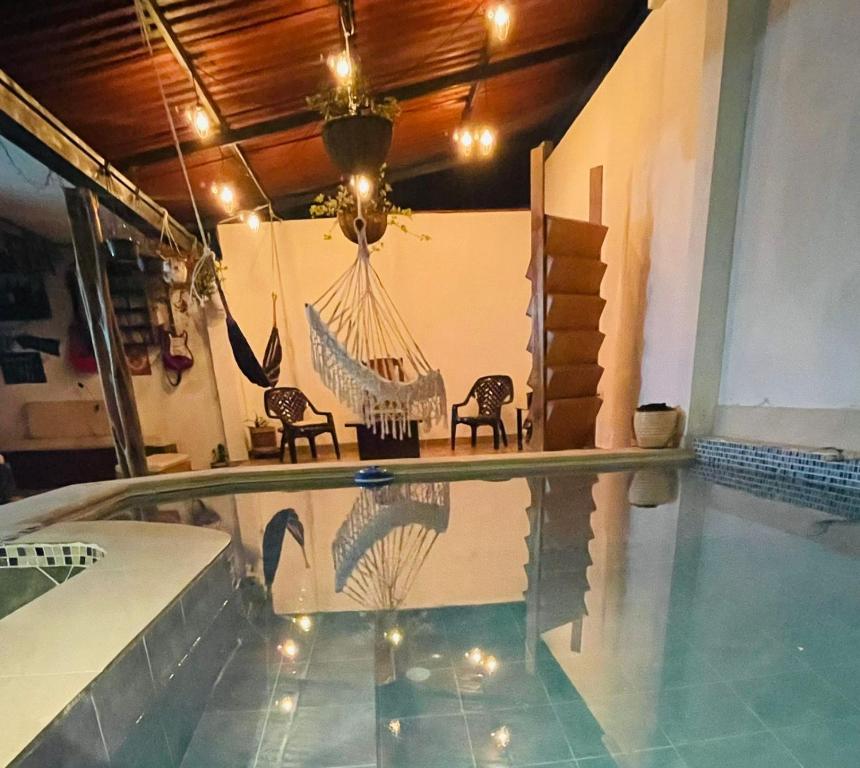 MocoaにあるCasa Hostal los Profesの家の中に椅子2脚とハンモックが備わったプール