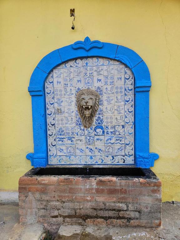 a blue gate with a lion on the side of a building at Casa temporada Vô Panta in Bichinho