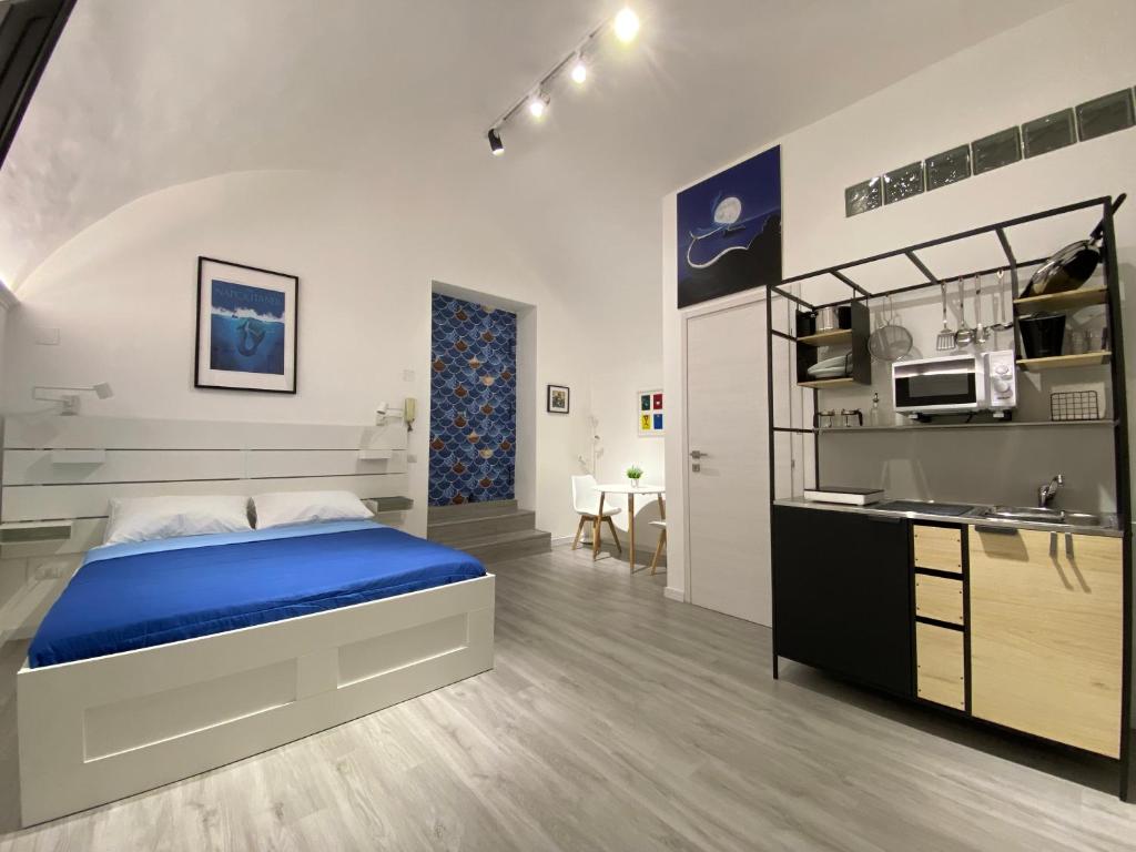 una camera con letto blu e una cucina di La Casa di Partenope a Napoli