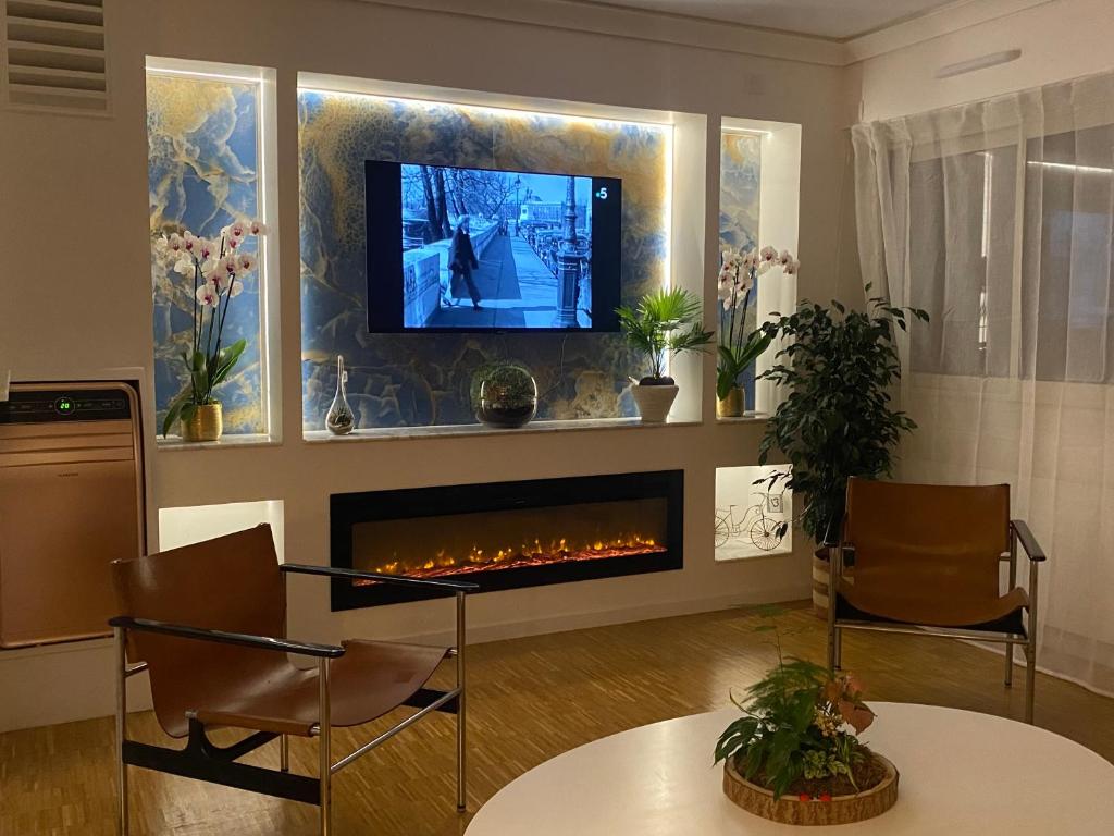 un salon avec une cheminée et une télévision dans l'établissement Luxurious and Glamorous Apartment, à Paris