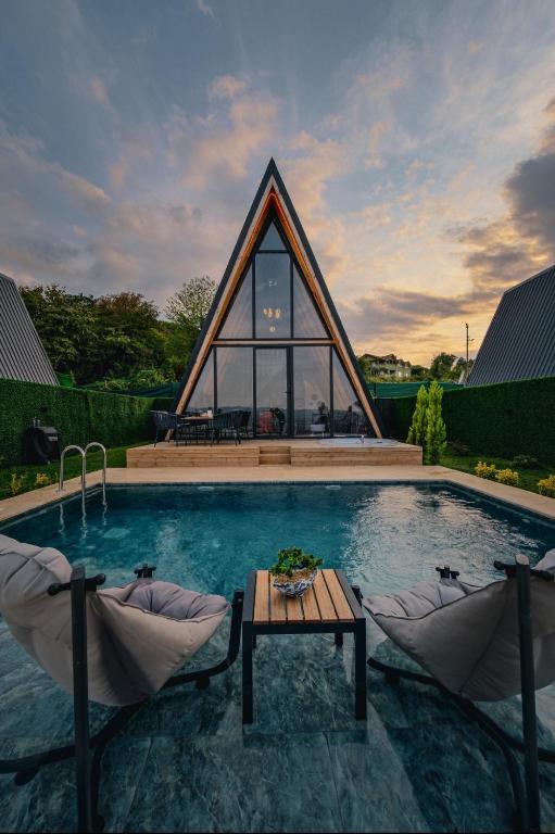 a pool with two chairs and a table in front of a building at Ala World Resort in Kartepe