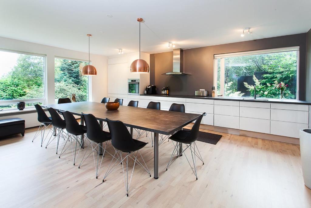 a large kitchen with a wooden table and chairs at Villa - South Iceland in Laugaras