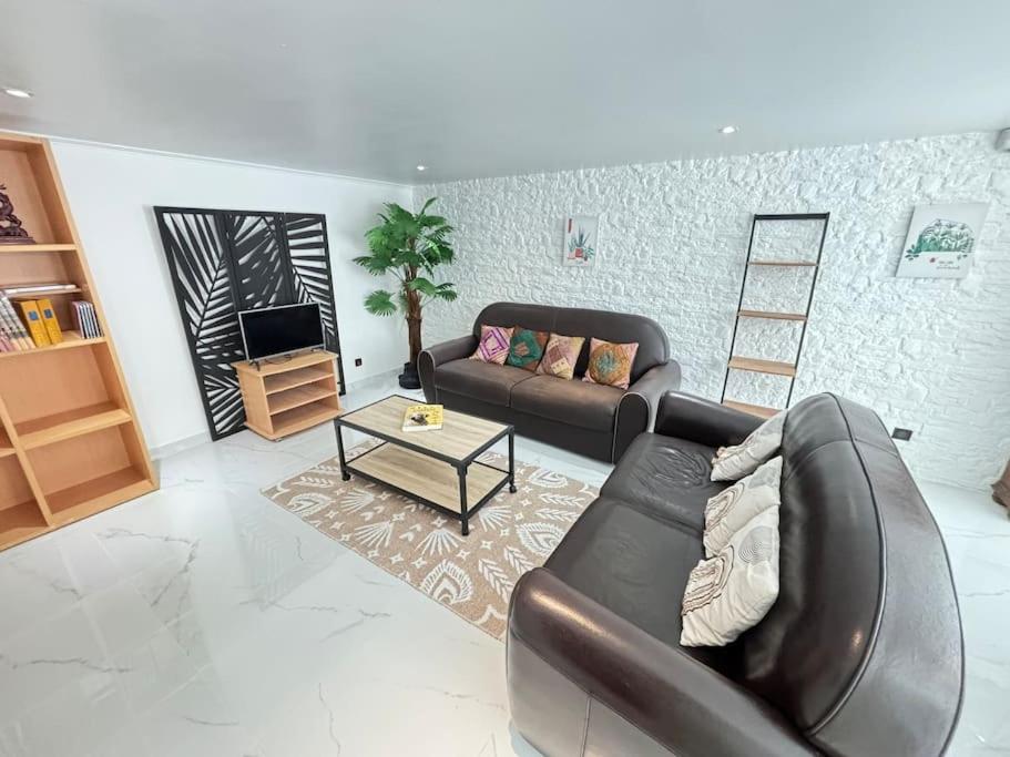 a living room with a couch and a table at confortable et spacieux 80m2 in Bailly-Romainvilliers