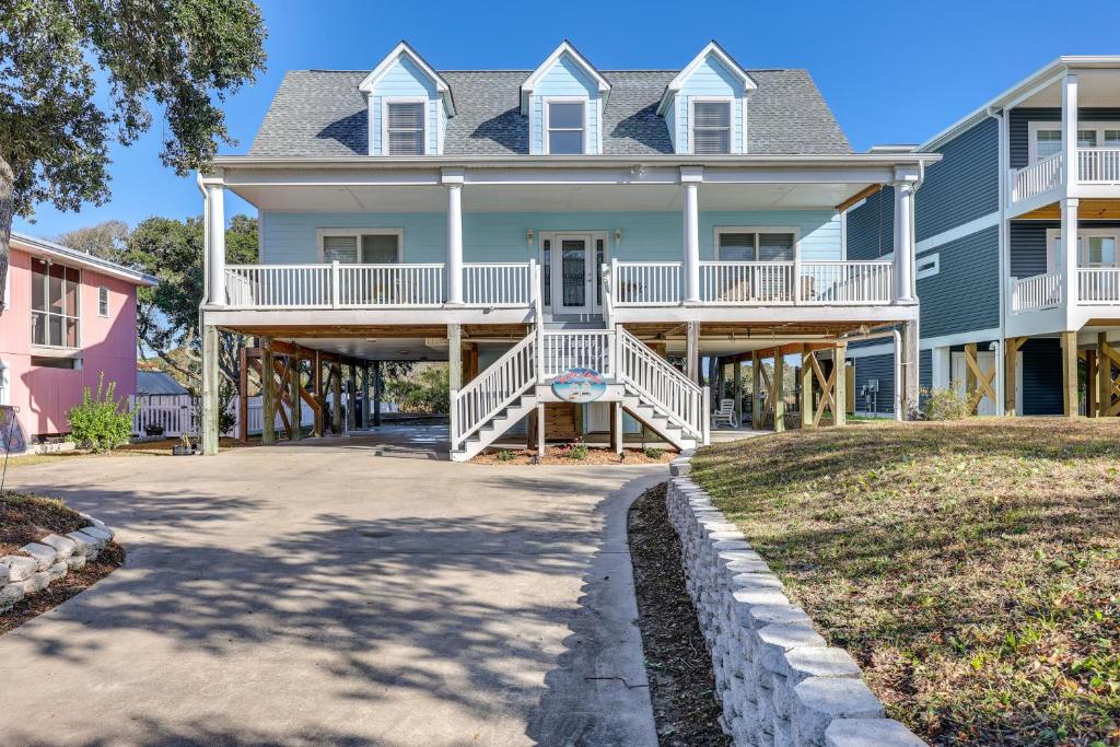 Waterfront Oak Island Home with Dock في أوك آيلاند: منزل كبير مع شرفة وممر