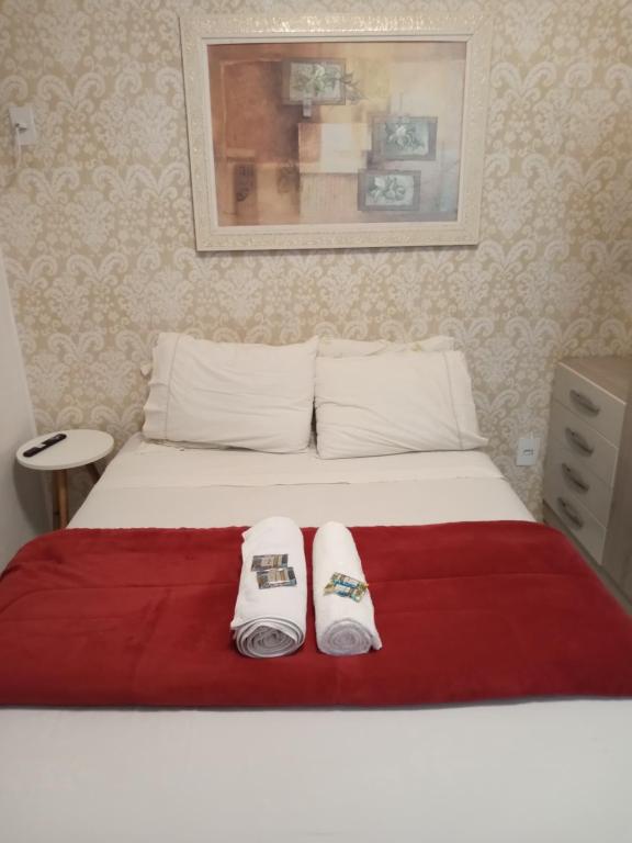 a bedroom with a bed with two towels on it at Aluguel de apartamento in São Leopoldo