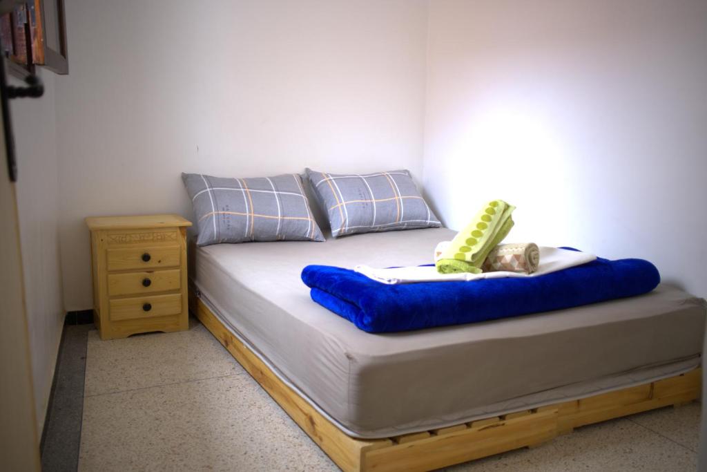 塔哈佐特Cozy By The Sea的一张带蓝色床垫和床头柜的床