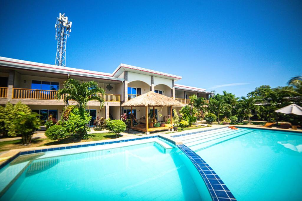 a swimming pool in front of a house at Buona Resort in Panglao