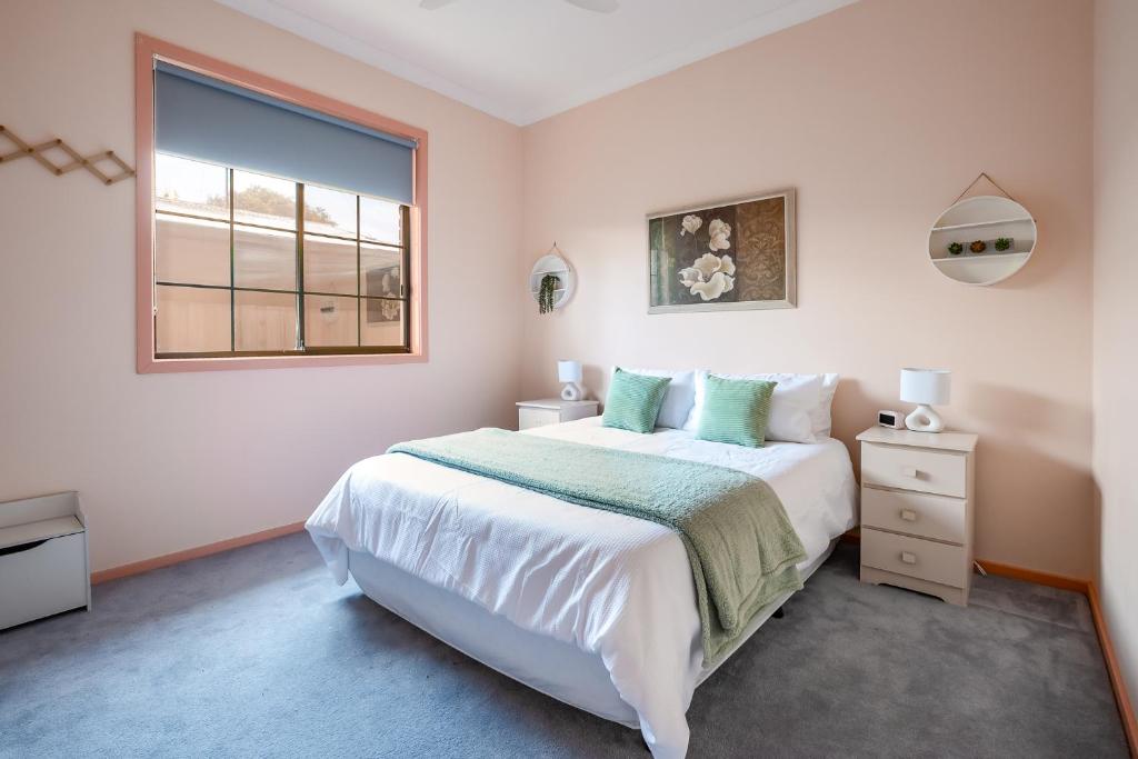 Un dormitorio con una cama grande y una ventana. en Family Beach House Near Barwon River & Beaches, en Barwon Heads
