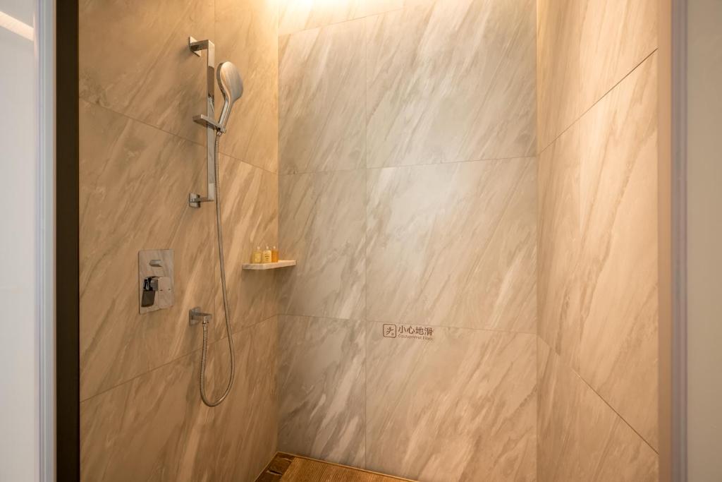 a bathroom with a shower with a shower head at Qinglian Jinghe Hotel Wuhan Zoo International Expo Center Branch in Han-yang-hsien