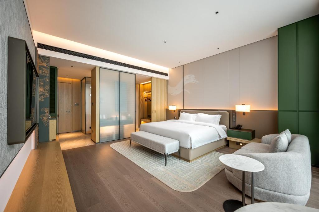 a hotel room with a bed and a couch at Qinglian Jinghe Hotel Wuhan Zoo International Expo Center Branch in Han-yang-hsien