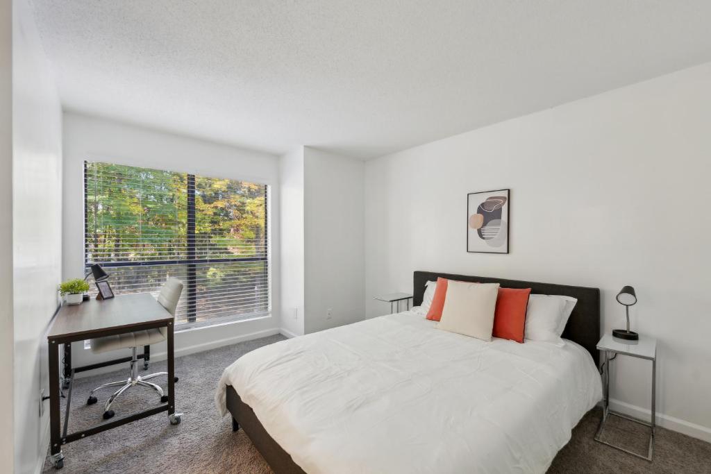 ウィンストン・セーラムにあるNorthcliffe 405 I Fully Furnished 2 Bedroom 2bthのベッドと机と窓のある寝室