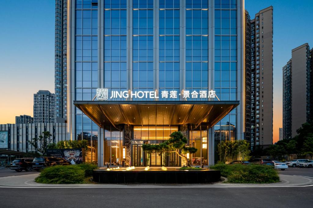 a building with a sign on it in a city at Qinglian Jinghe Hotel Wuhan Zoo International Expo Center Branch in Han-yang-hsien