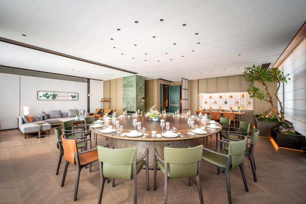 a dining room with a large table and chairs at Qinglian Jinghe Hotel Wuhan Zoo International Expo Center Branch in Han-yang-hsien