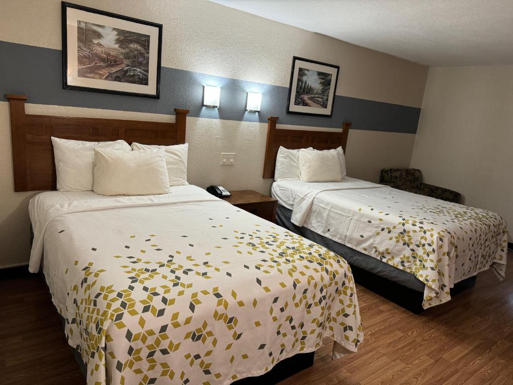 a hotel room with two beds with white sheets at Americas Best Value Inn Marshall in Bel Air