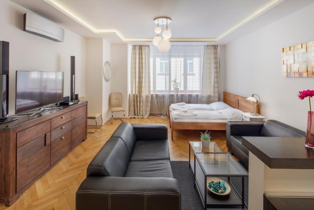 uma sala de estar com um sofá e uma televisão em Selinor Old Town Apartments em Praga