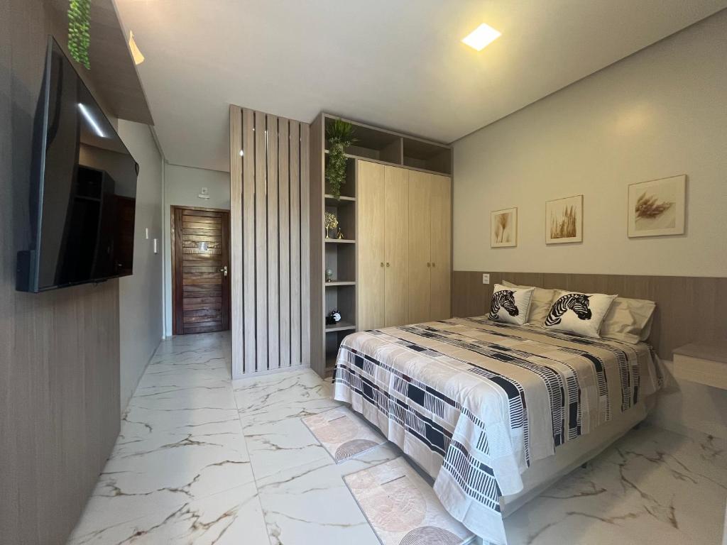 a bedroom with a bed and a flat screen tv at Flat Paraíso da Praia 20324 in Santarém