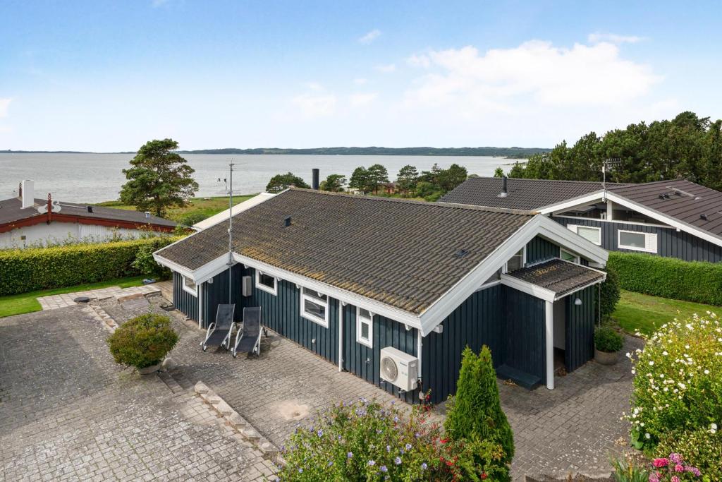 an aerial view of a blue house with the ocean in the background at Beautiful Summer House With Sea View Near Ebeltoft in Ebeltoft