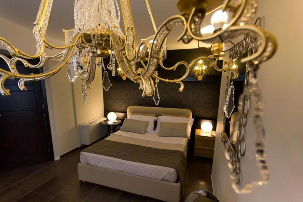 1 dormitorio con cama y lámpara de araña en Casa Vacanze Lidia, en Balestrate