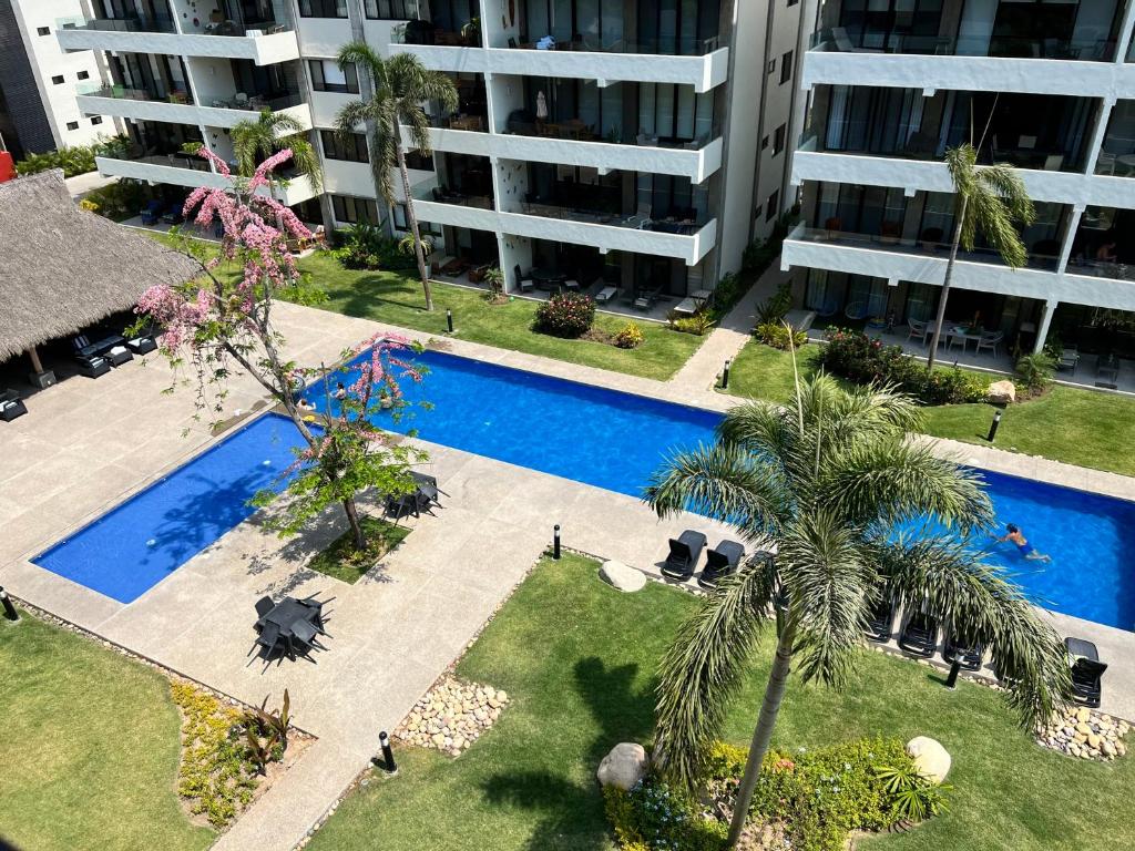 ヌエボ・バジャルタにあるNuevo Vallarta Condo nuevo y moderno a 5 min de playas PTRC17のアパートメントビル内のスイミングプールのオーバーヘッドビュー
