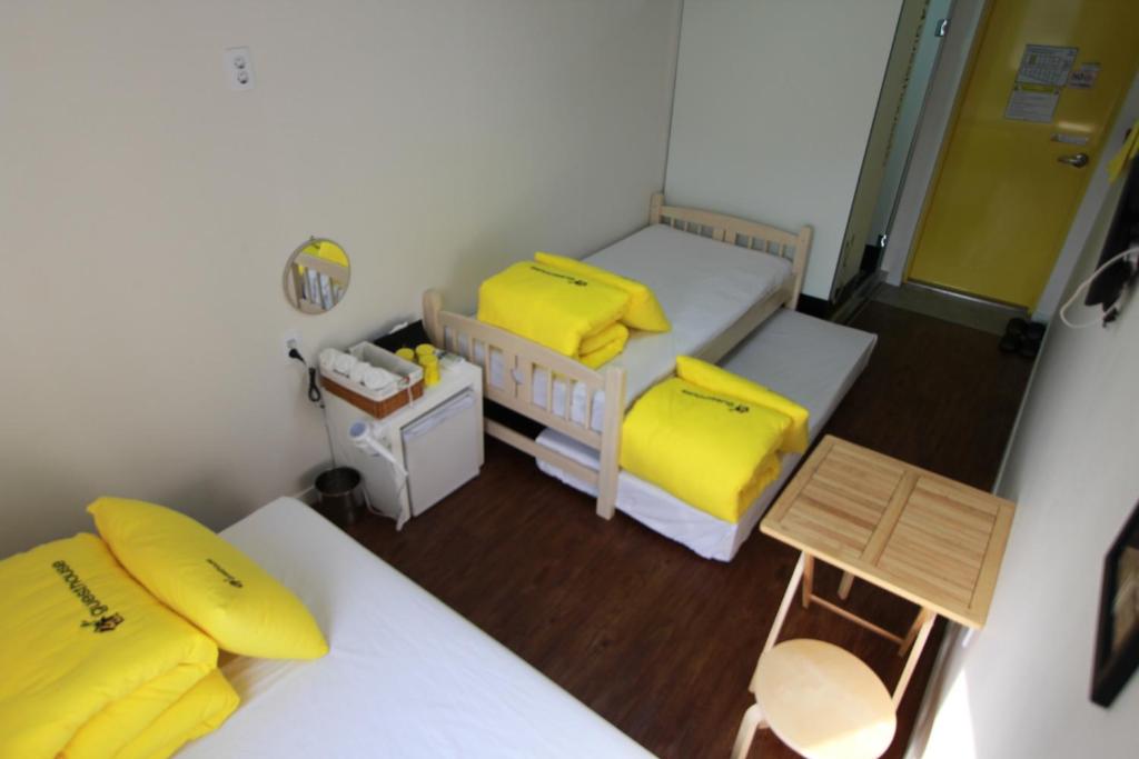 2 Betten in einem kleinen Zimmer mit gelben Kissen in der Unterkunft 24 Guesthouse Myeongdong Town in Seoul
