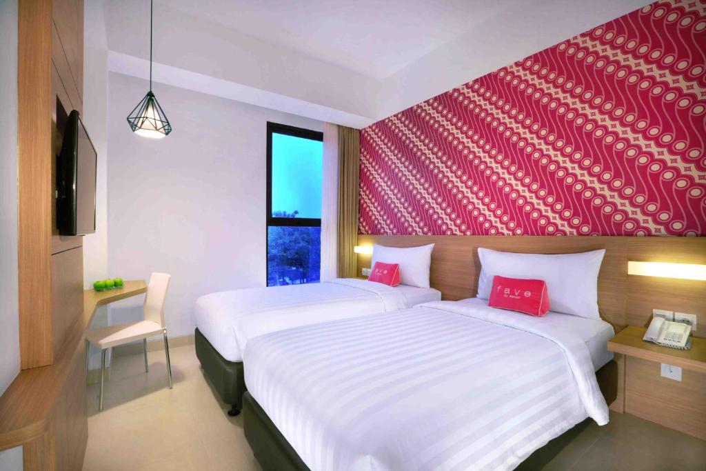 Postel nebo postele na pokoji v ubytování favehotel Malioboro - Yogyakarta