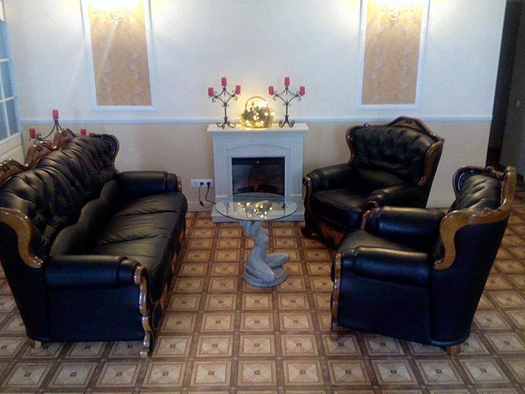 a waiting room with leather chairs and a fireplace at Central Hotel in Narva
