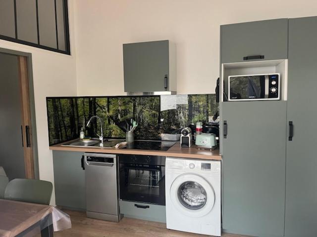 une cuisine avec un réfrigérateur et une machine à laver dans l'établissement Location havre de paix, à Gourbera