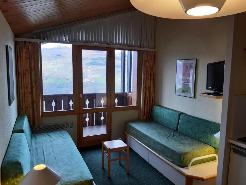 un salon avec un canapé et une fenêtre dans l'établissement Résidence Le Sextant - maeva Home - 2 Pièces 5 Personnes Confort MAE-4595, à La Plagne Tarentaise