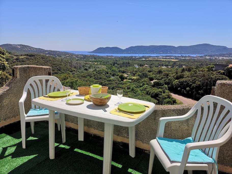une table blanche avec deux chaises et une table avec vue dans l'établissement La Tour dans haut de villa, à Porto-Vecchio