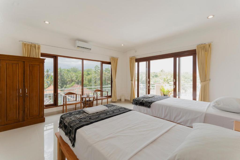 sypialnia z dwoma łóżkami i balkonem w obiekcie Hotel Umah Anyar Teges w mieście Ubud
