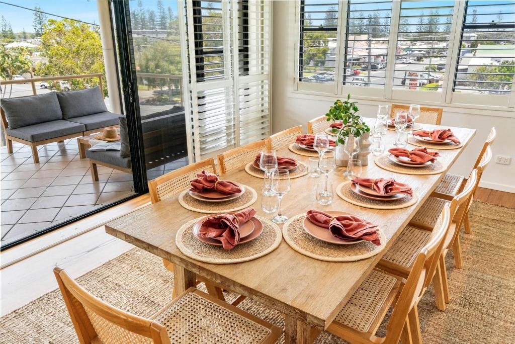 a dining room table with plates of food on it at Cowrie House - Spacious, Modern holiday home in Yamba