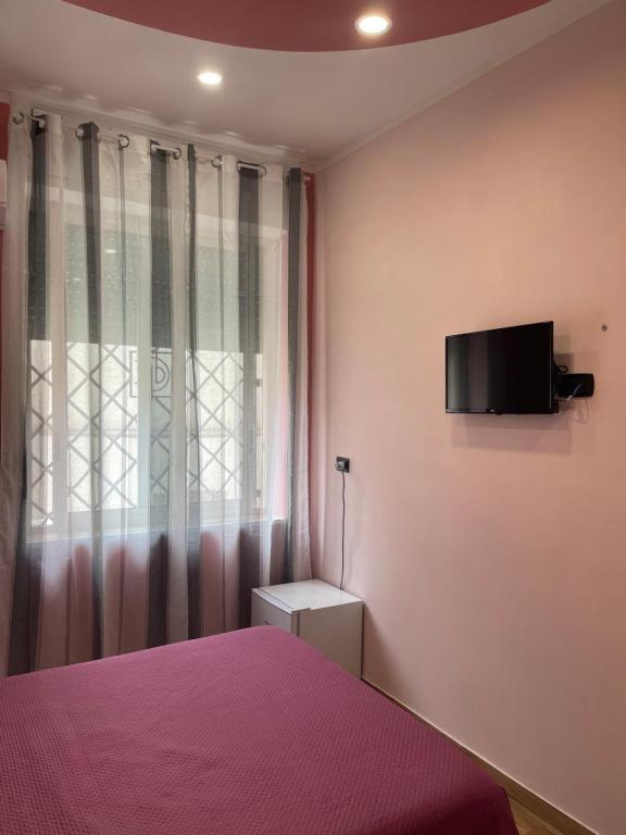 a bedroom with a bed and a tv on the wall at B&B Son De Mar in Salerno