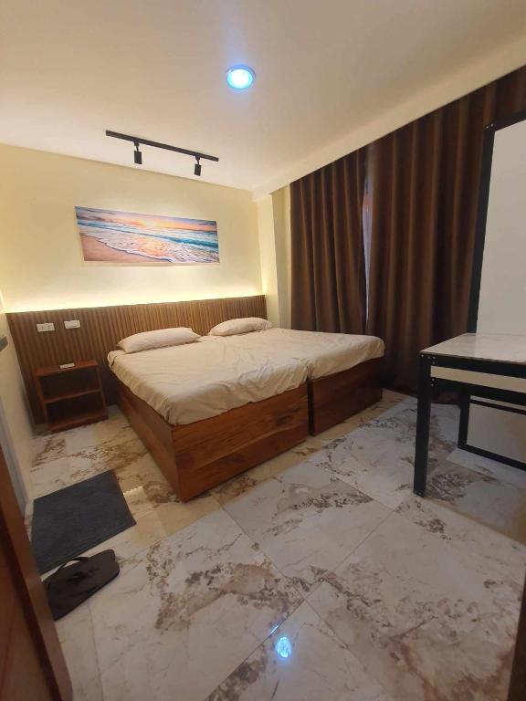 a bedroom with a bed and a table in it at JMC4 Cozy Room1 Near Alona Beach in Panglao