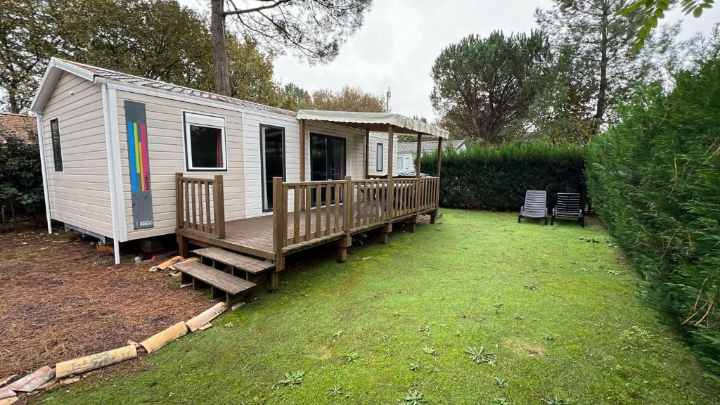 una casetta bianca con portico e terrazza di Mobil Home 220 aménagé 2 chambres la teste camping 4 etoiles a La Teste-de-Buch