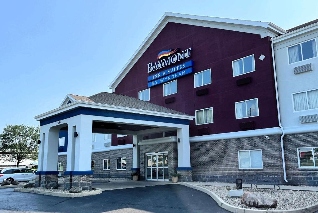 a hotel with a red building with a sign on it at Baymont by Wyndham Indianapolis Northeast in Indianapolis